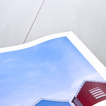 Beach huts in a row against sky by Assaf Frank